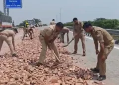 चलते डंपर से हाईवे पर बिछ गई पत्थरों की चादर! हादसे का खतरा देख फावड़ा लेकर सड़क पर उतरी यूपी पुलिस